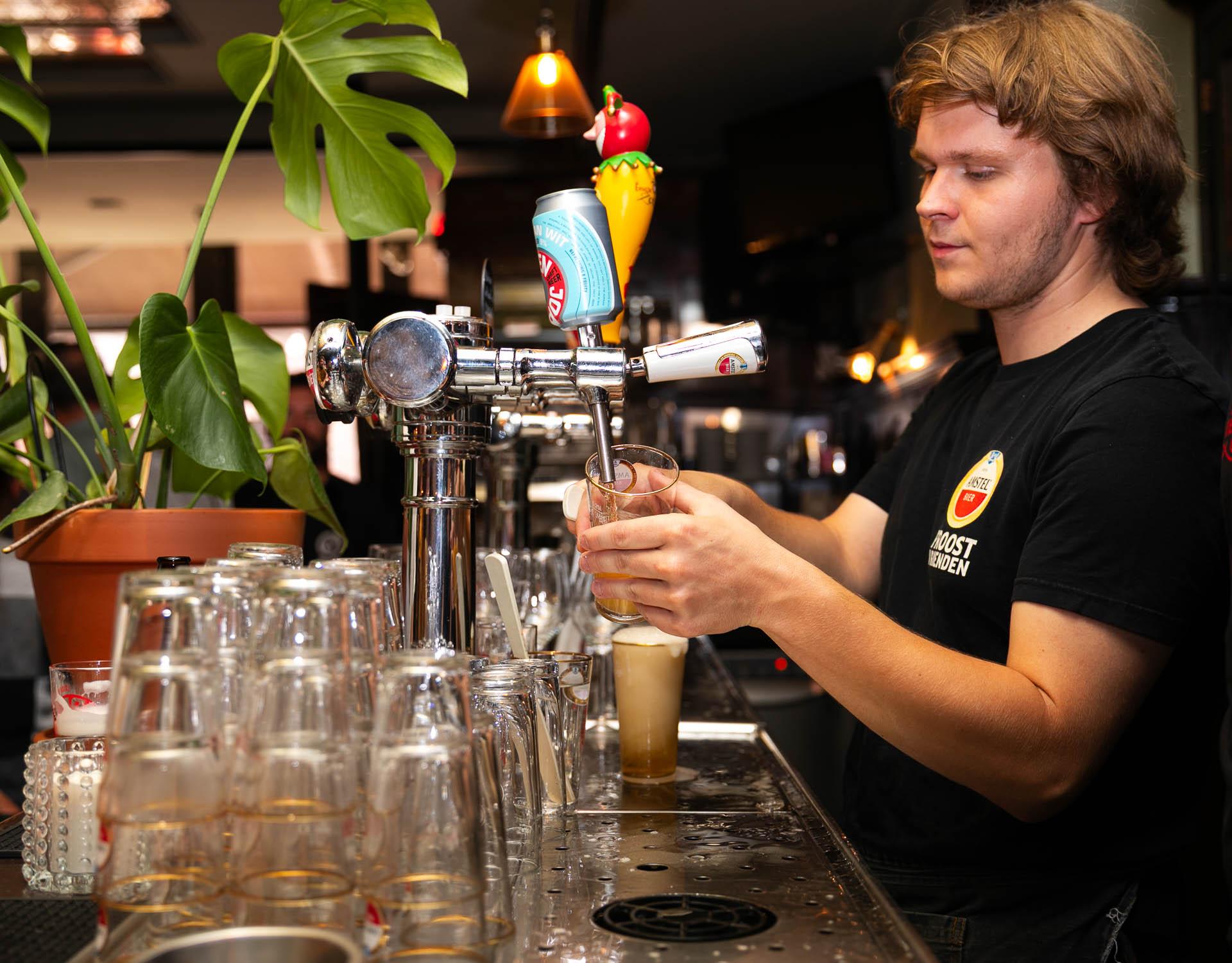 Reinoud tapt een biertje achter de bar van Café De Lift